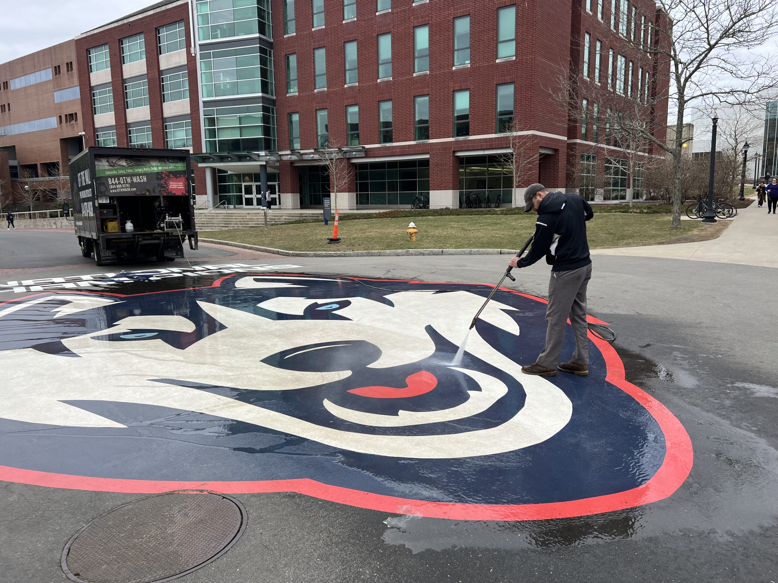 this is a picture of OFF THE WALL Power washing the UCONN logo.