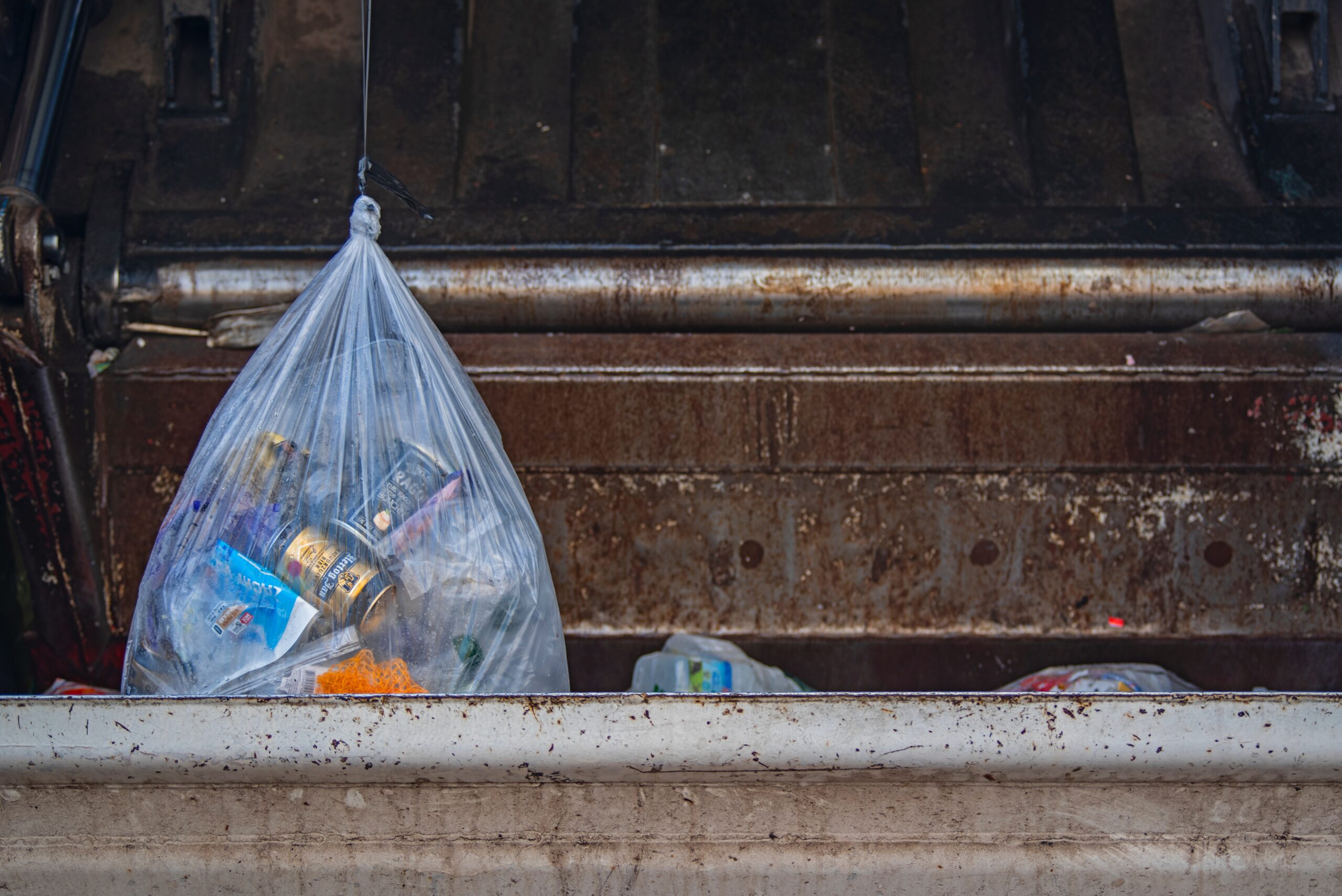 trash being loaded into a dumpster