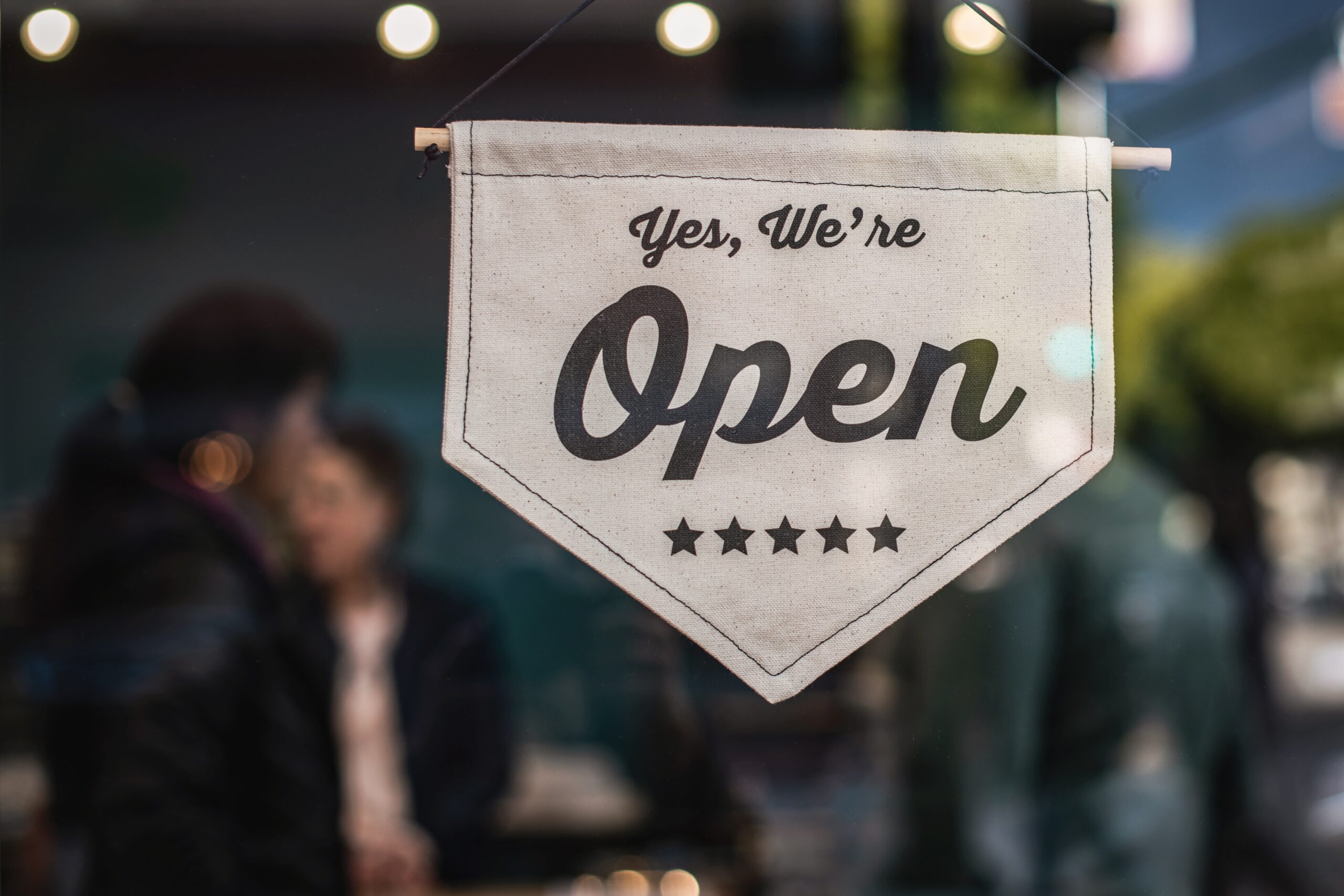 image of an open sign hanging in the window of a small business