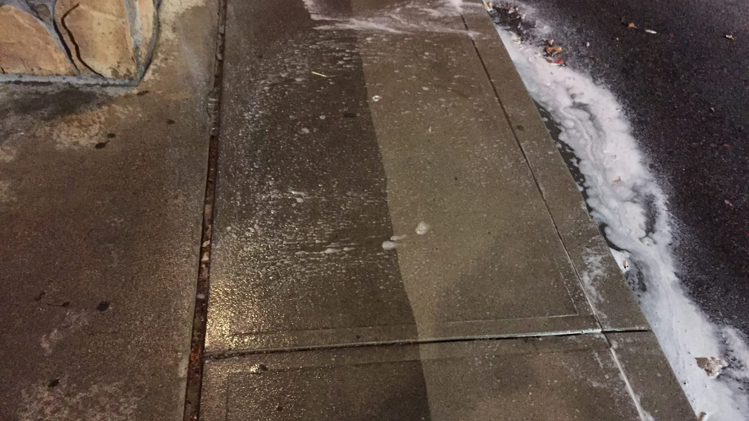 photo showing the process of cleaning a dirty sidewalk