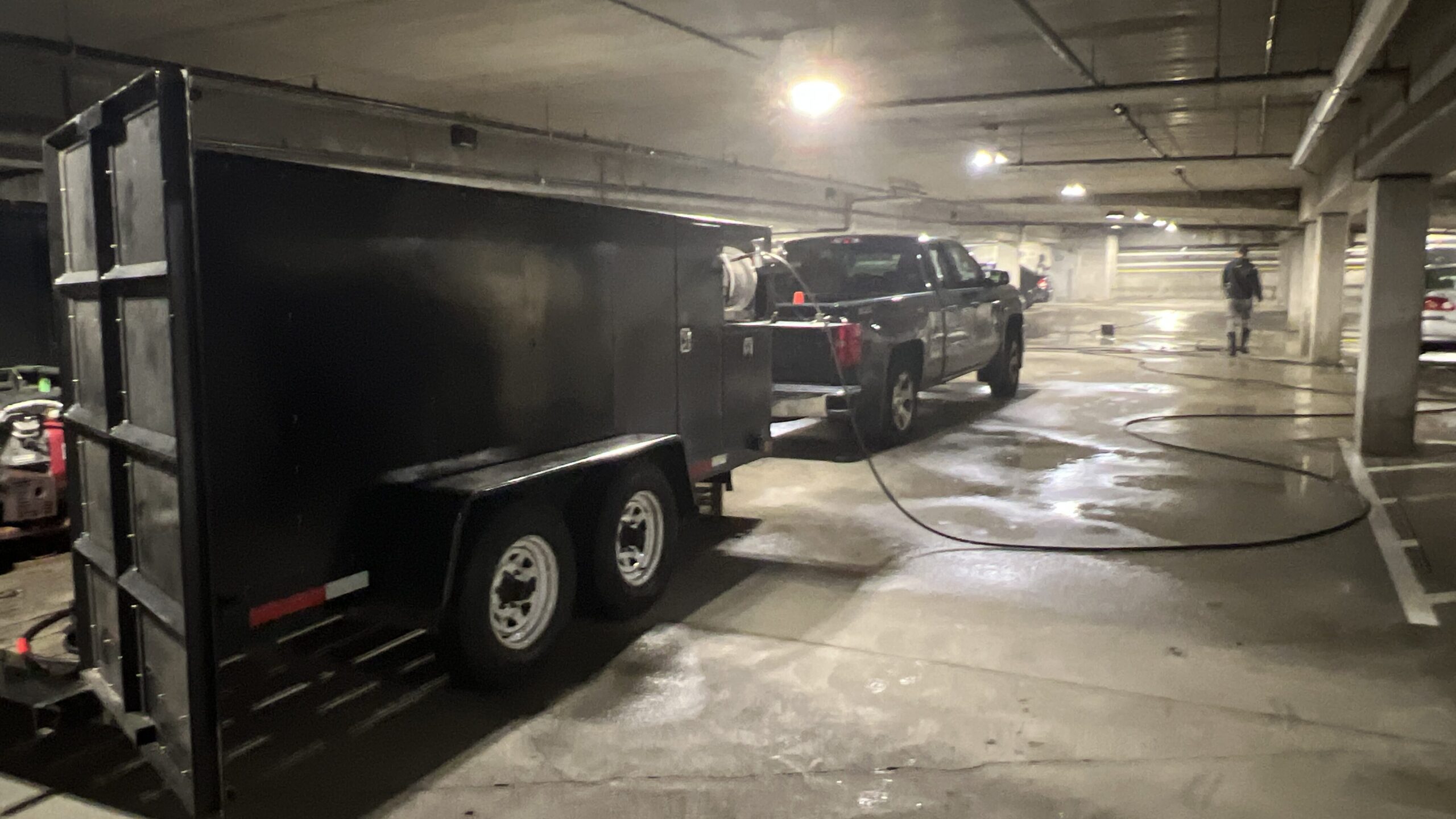 photograph of a team of power washers cleaning a parking garage