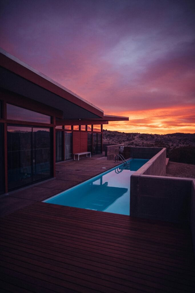 Photograph of the sun setting as seen from a freshly pressure washed deck outside a luxury residence