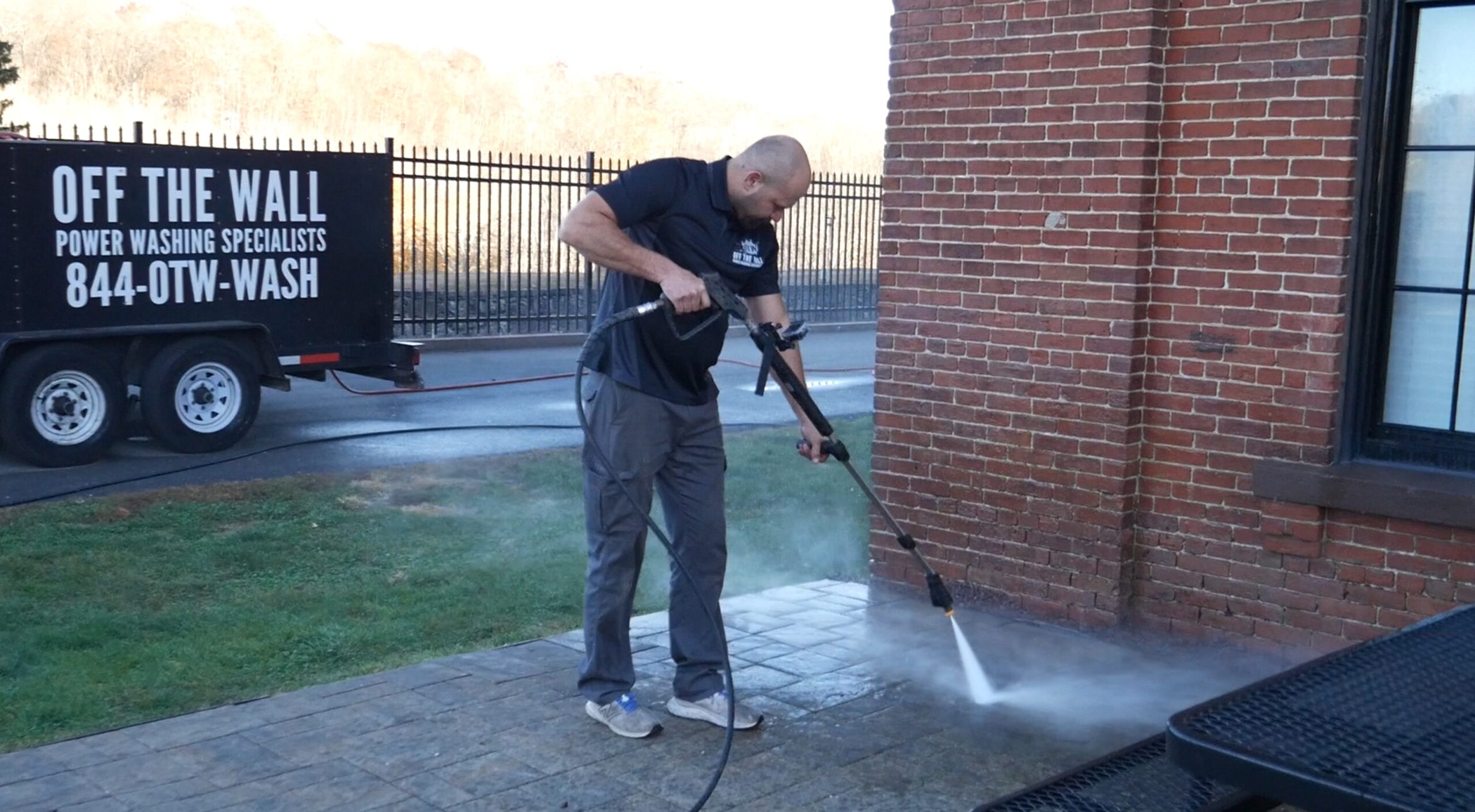 photo of an OFF THE WALL team member power washing a sidewalk in CT