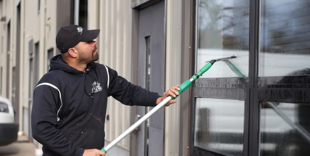 photo of an OFF THE WALL team member performing window washing service in CT