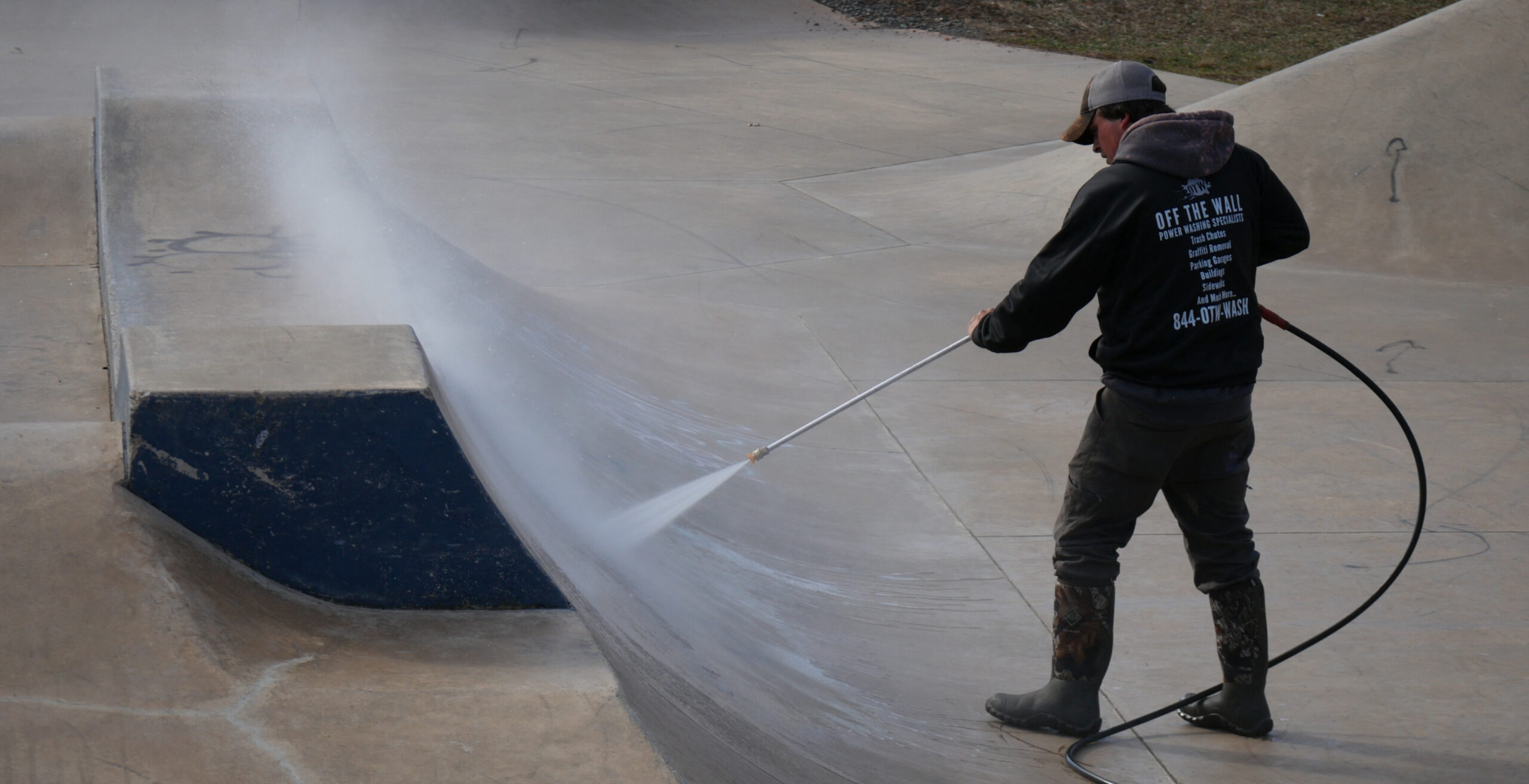 photograph of an OFF THE WALL team member power washing a skateboard ramp in Newington, CT