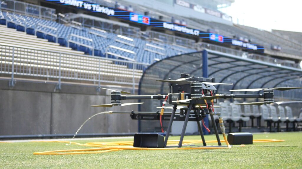 photograph of the OFF THE WALL power washing drone after landing in a stadium