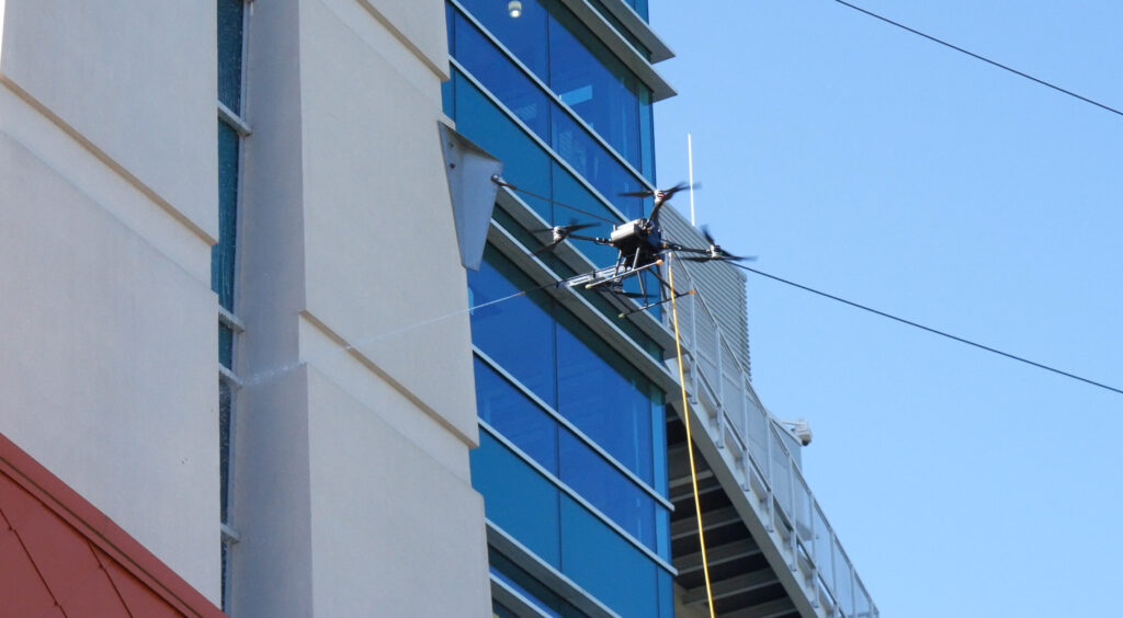 photo of the OFF THE WALL Power Washing drone cleaning the Goodwin University tower in East Hartford, CT