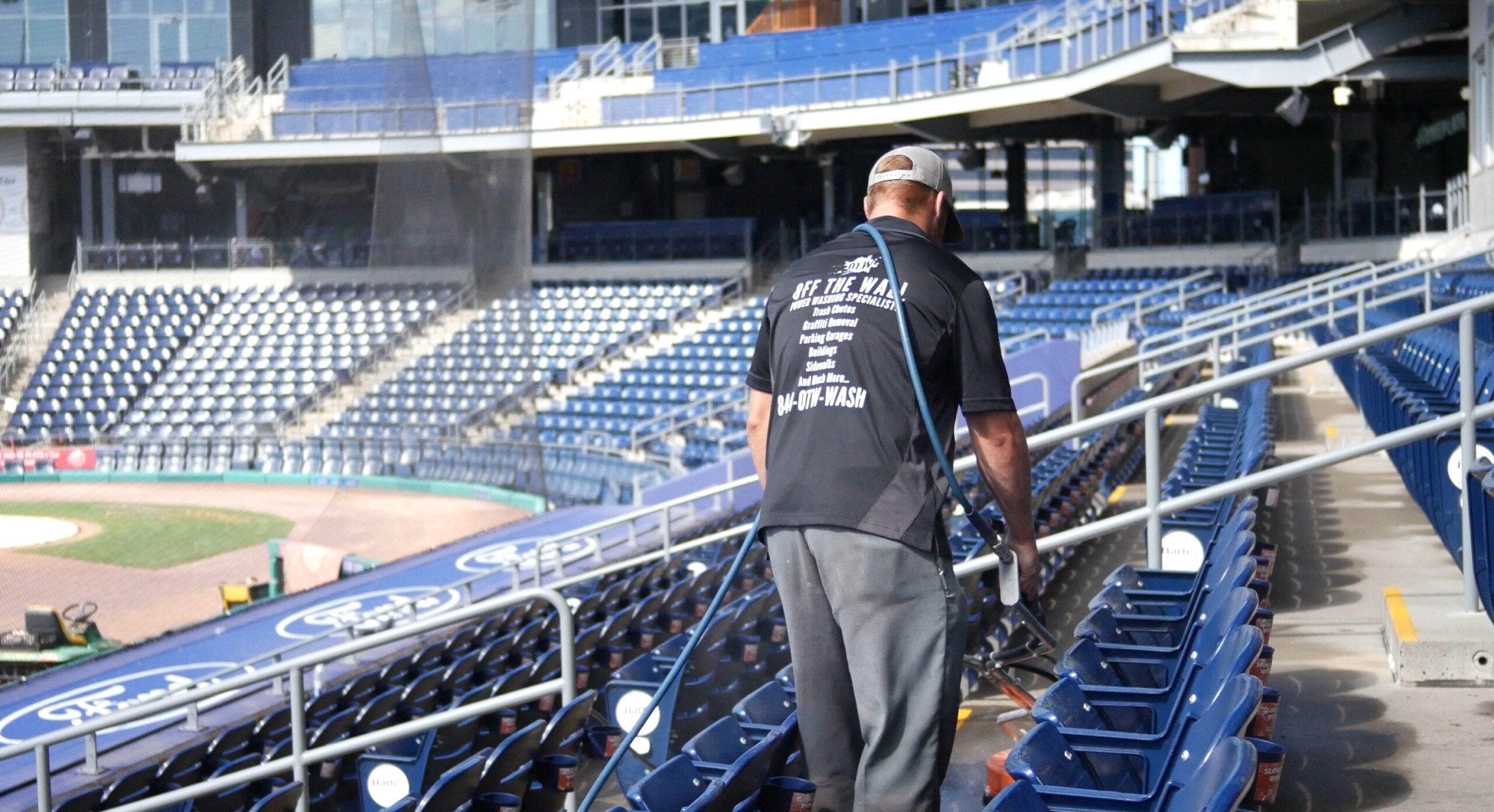 photo of an OFF THE WALL team member cleaning the concrete at Dunkin Park in Hartford, CT