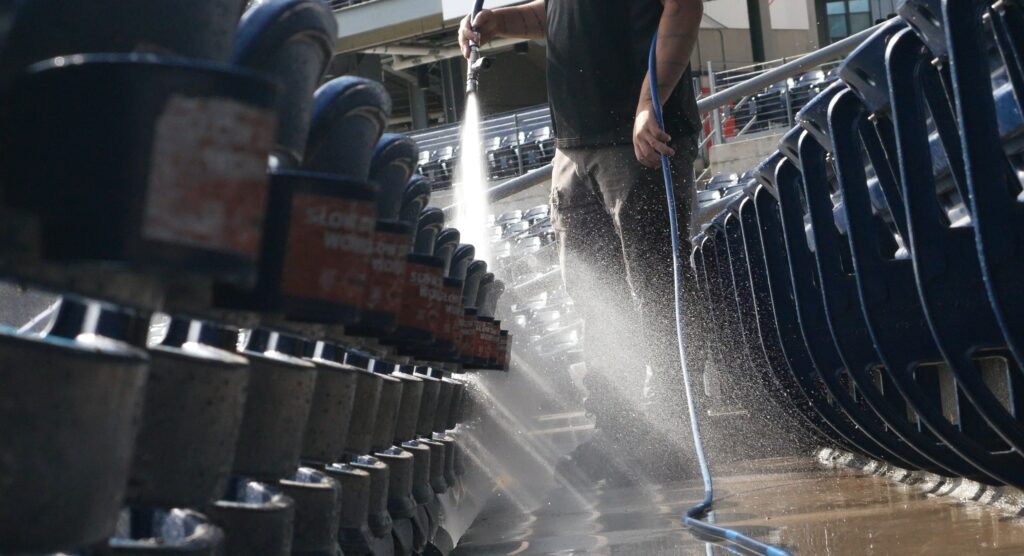 photo of an OFF THE WALL team member rinsing the seating at Dunkin Park in Hartford, CT