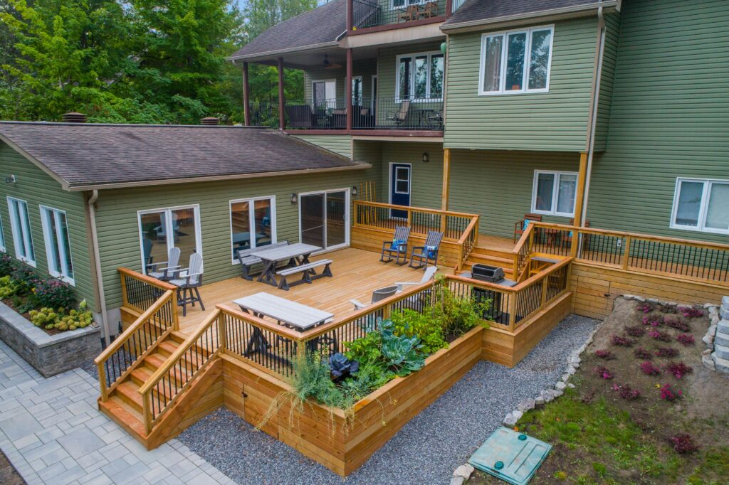 photograph of a sprawling deck in the backyard of a large middle-class home