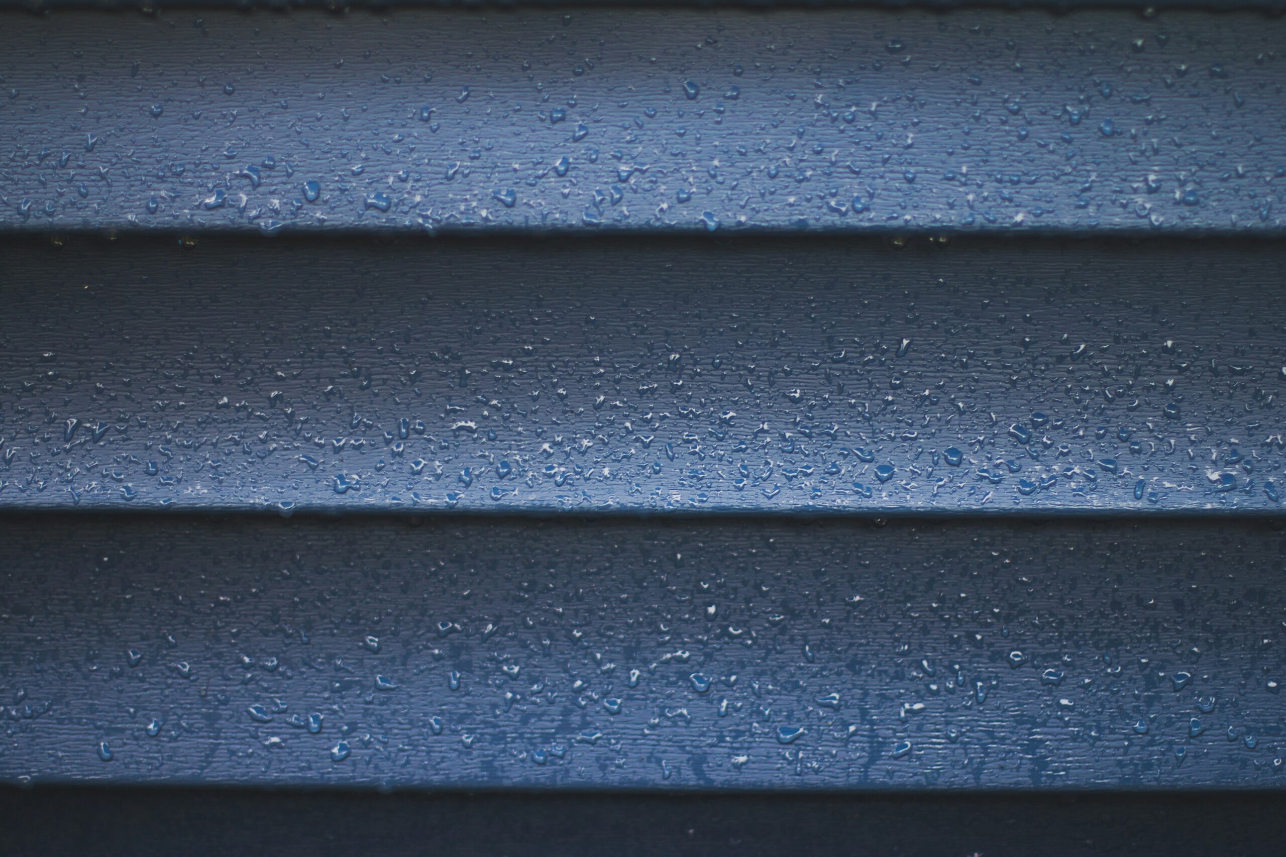 photograph showing beads of water glistening on freshly pressure washed vinyl siding