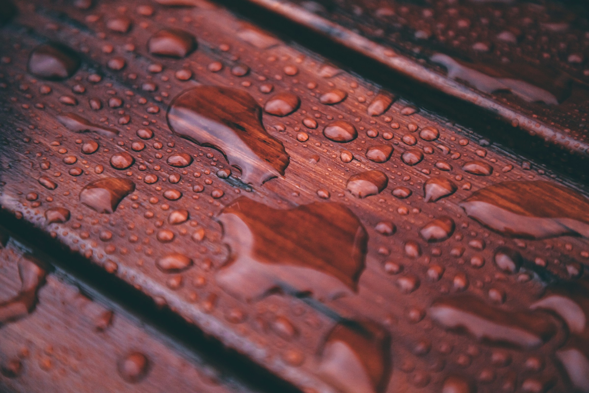 image of red-stained deck boards beaded with droplets of water
